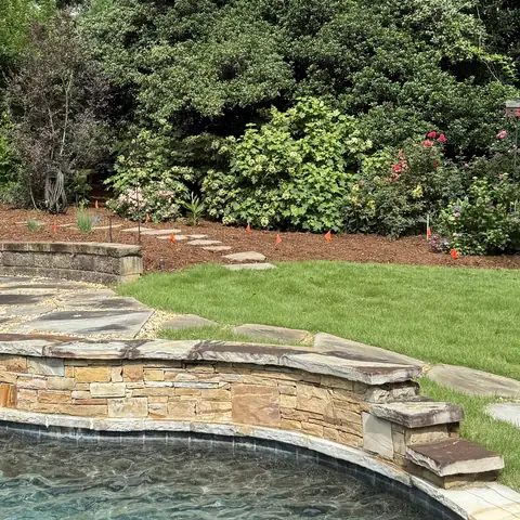 After: the same beds freshly mulched, seen from across the pool